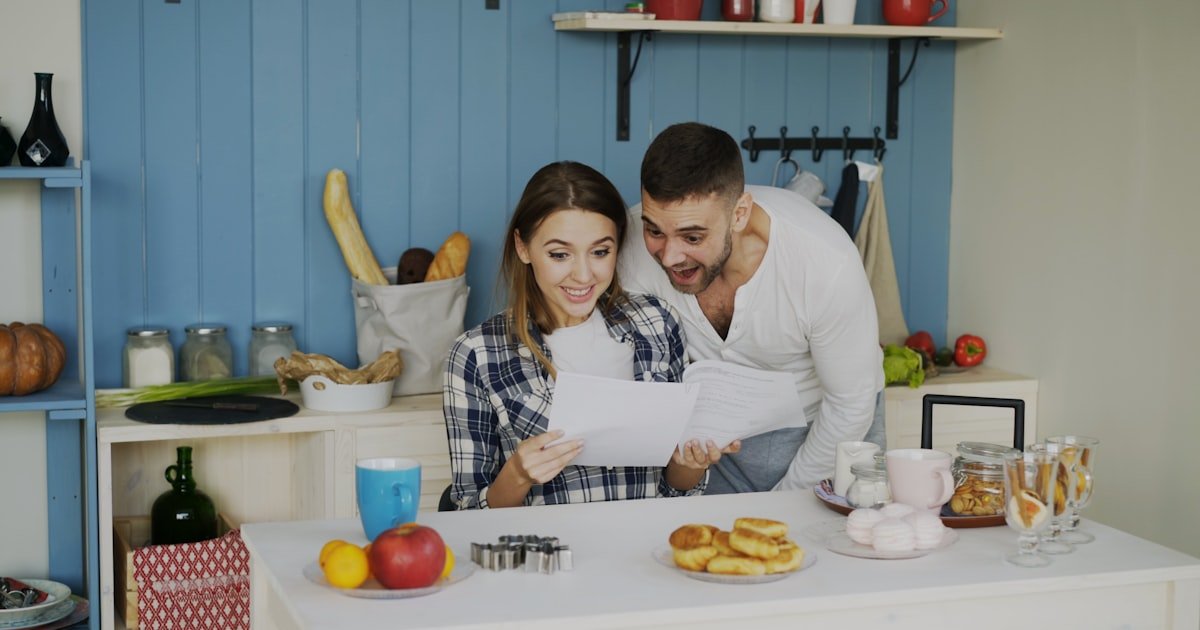 A couple reviewing their household budget together at the kitchen table