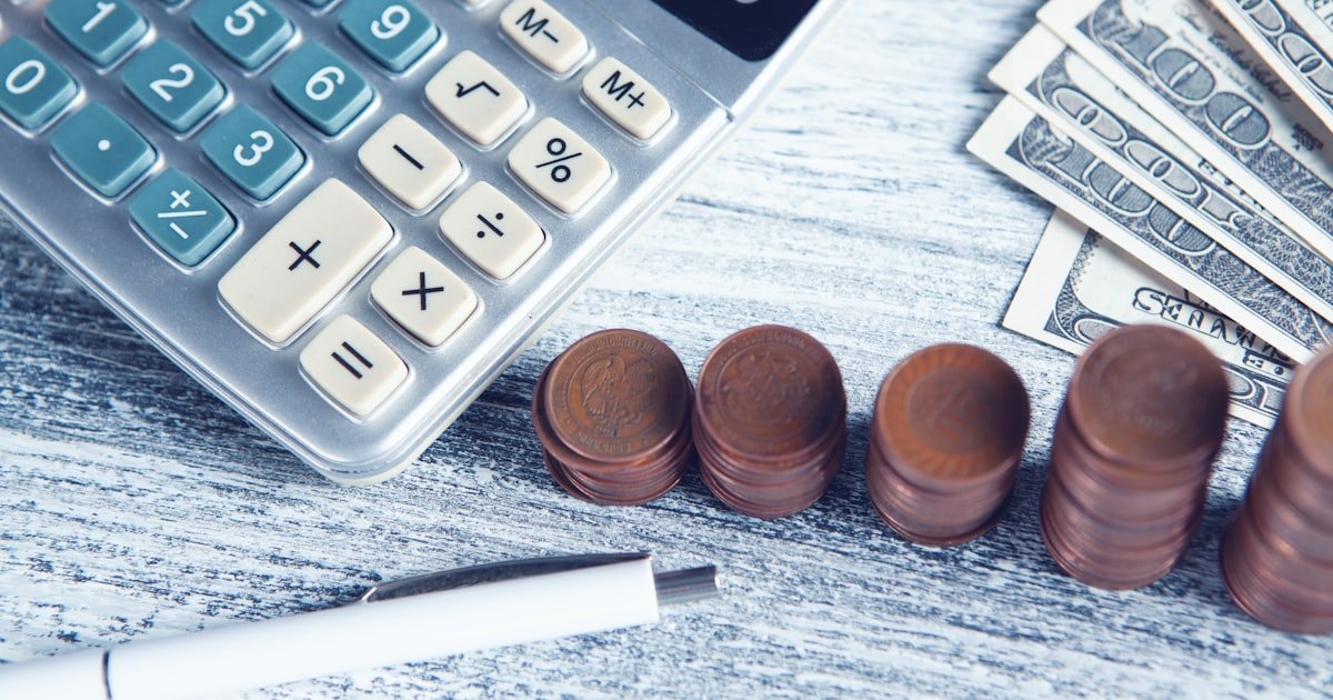 Calculator and cash on a desk while reviewing a credit score